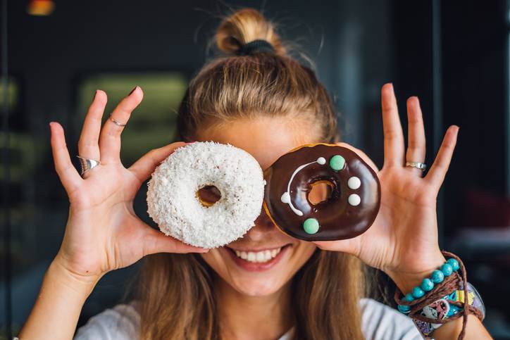 Happy woman holding donuts